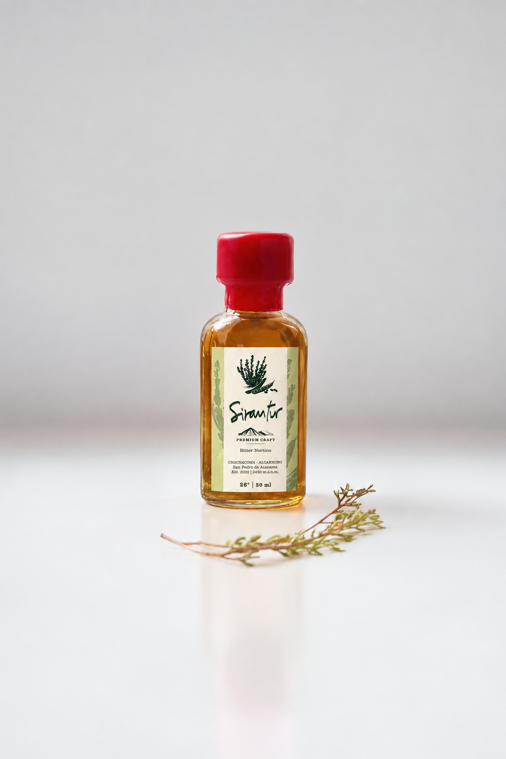 Frasco de Sirantur 50 ml, bitter nortino de chachacoma y algarrobo, con una rama de chachacoma